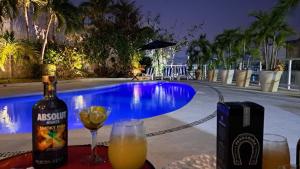 a bottle of wine and glasses next to a swimming pool at Villa Casa blanca Con Alberca privada in Acapulco