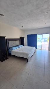 a bedroom with a bed and a blue wall at Villa Casa blanca Con Alberca privada in Acapulco