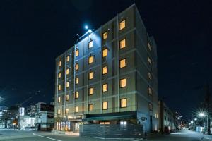 ein hohes Gebäude mit vielen Fenstern bei Nacht in der Unterkunft OKINI - Doyanen Hotels in Osaka