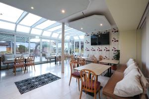 a dining room with glass ceilings and tables and chairs at Arthotel ANA Panorama, Trademark Collection by Wyndham in Marktoberdorf