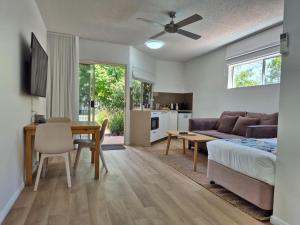 a living room with a bed a table and a couch at Noosa Sun - On the Noosa River in Noosaville