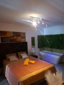 a bedroom with a bed and a bath tub at Le Maloha in Le Gosier