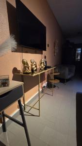 a living room with a table with a flat screen tv at Le Maloha in Le Gosier