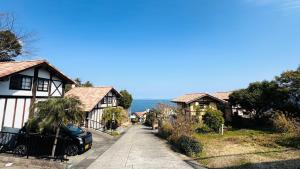eine Straße in einem Dorf mit Häusern auf einem Hügel in der Unterkunft Amakusa LogHouse UmiOTO 海音 in Amakusa