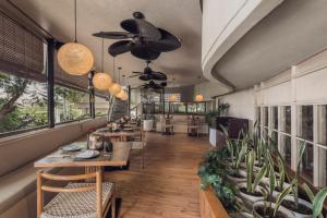 a restaurant with tables and chairs and a ceiling fan at Sini Vie Resort & Spa Seminyak by Ini Vie Hospitality in Seminyak