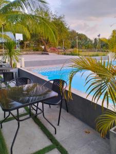 a table and chairs next to a swimming pool at PNAF Farm resort in Pililla