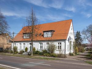 a white house with an orange roof on a street at Stilvolles Studio nahe Müritzsee in Buchholz in Buchholz