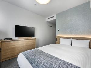 a bedroom with a bed and a flat screen tv at Daiwa Roynet Hotel Tokyo Akabane in Tokyo
