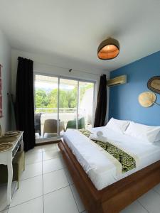 a bedroom with a large bed with a blue wall at Le Reka du Grand Large in Papeete +11 photos