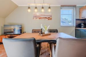 a dining room with a wooden table and chairs at Witter Barg - Ferienwohnung mit Sauna in Koserow
