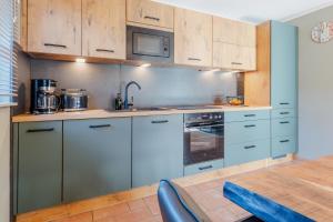 a kitchen with white cabinets and a wooden table at Witter Barg - Ferienwohnung mit Sauna in Koserow