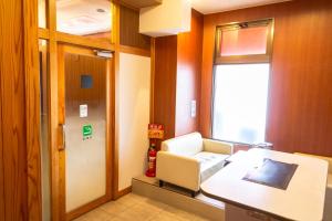 a hospital room with a chair and a window at APA Hotel Kochi in Kochi