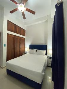 a bedroom with a bed with a ceiling fan at CEDOTURT Hotel Boutique & Escuela in Santo Domingo
