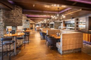 a restaurant with tables and chairs and a bar at Hilton Queenstown Resort & Spa in Queenstown