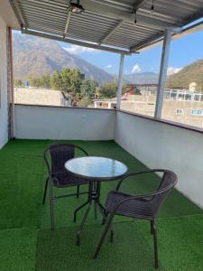 a table and two chairs on a balcony with a view at Borde del lago in Panajachel