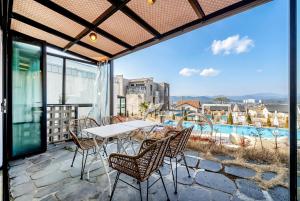 a patio with a table and chairs on a balcony at Gyeongju heybreeze Pool Villa in Gyeongju