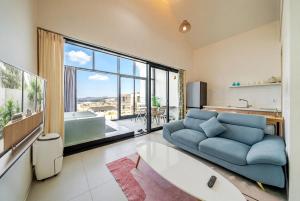a living room with a blue couch and a large window at Gyeongju heybreeze Pool Villa in Gyeongju