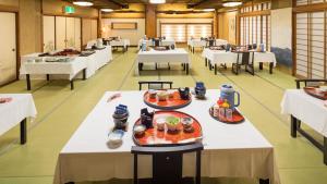 a cafeteria with white tables with food on them at Yamaga Onsen Sumi in Yamaga