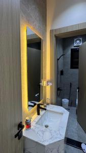 a bathroom with a sink and a large mirror at The Queen Apartment in Jeddah +5 photos