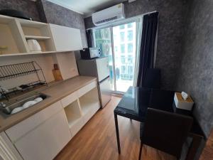 a small kitchen with a table and a window at Modern Grey in Udon Thani