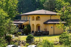a large yellow house with a porch at Gapyeong Ruba Pension in Gapyeong