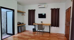 a room with a desk and a table with a chair at Nubdao Resort&Restaurant in Nong Prue