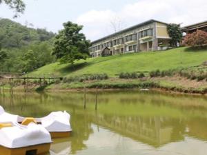 una casa su una collina vicino a un corpo d'acqua di Landmark Woods a Kāziranga