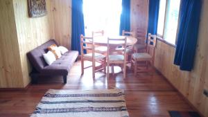 a living room with a table and chairs and a couch at Cabaña Pucon a Huife in Pichare