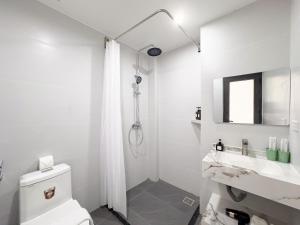 a white bathroom with a toilet and a sink at Louis Home in Danang