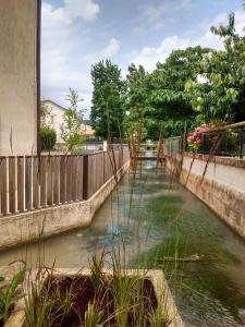 una corriente de agua en un patio con una valla en Casa Kaletheia, en Volpago del Montello