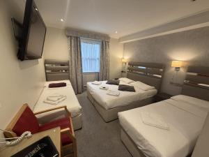 a hotel room with two beds and a television at Admiral Hotel at Park Avenue in London