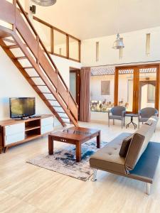 a living room with a staircase with a couch and a table at Bedugul Lake View Inn in Bedugul