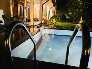 a swimming pool in front of a house at night at Sigiri Yahana in Sigiriya