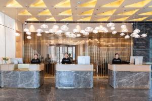 a group of women sitting at reception desks in a lobby at Atour Hotel Hefei Yaohai Heping Road in Hefei