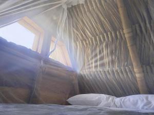 a bedroom with a canopy bed with a window at Cabanas ecologicas con vista espectacular y cascada privada - Finca Qawana Ecolodge en San Carlos in Cristalina