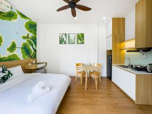 a bedroom with a bed and a kitchen with a table at Louis Home in Danang