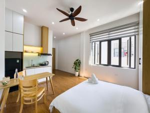 a bedroom with a bed and a table and a kitchen at Louis Home in Danang +20 photos