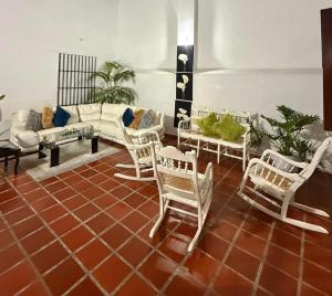 a living room with white chairs and a couch at Casa Mashala in Santa Cruz de Mompox