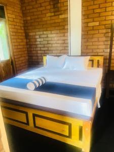 a large bed in a room with a wooden wall at Sigiri Yahana in Sigiriya