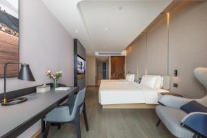 a hotel room with a bed and a desk at Atour Hotel Hefei Yaohai Heping Road in Hefei