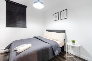 a white bedroom with a bed and a table at Appartement Deux chambre Griffin Town in Montreal +6 photos