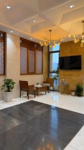 a lobby with a flat screen tv and a table at Nizwa Inn - نزوى إن in Nizwa