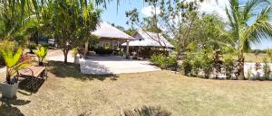 a house with a thatch roof and a yard at PNAF Farm resort in Pililla