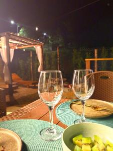 two wine glasses and a bowl of fruit on a table at Cabana da Lua Chalés Vero Verde in Serra Negra