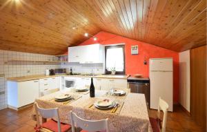 a kitchen with a table and a white refrigerator at Awesome Apartment In Sovramonte With Wifi in Sovramonte