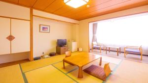 a living room with a table and a tv at グリーンピア三陸みやこ in Miyako