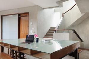 an office with a glass table with a laptop on it at Urbanview Hotel The Lodge Karawaci in Tangerang
