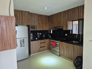 a kitchen with wooden cabinets and a white refrigerator at Finca Sierra Madre in Durango +7 photos