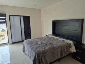 a bedroom with a large bed and a large flat screen tv at Finca Sierra Madre in Durango