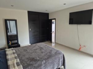 a bedroom with a bed and a flat screen tv at Finca Sierra Madre in Durango